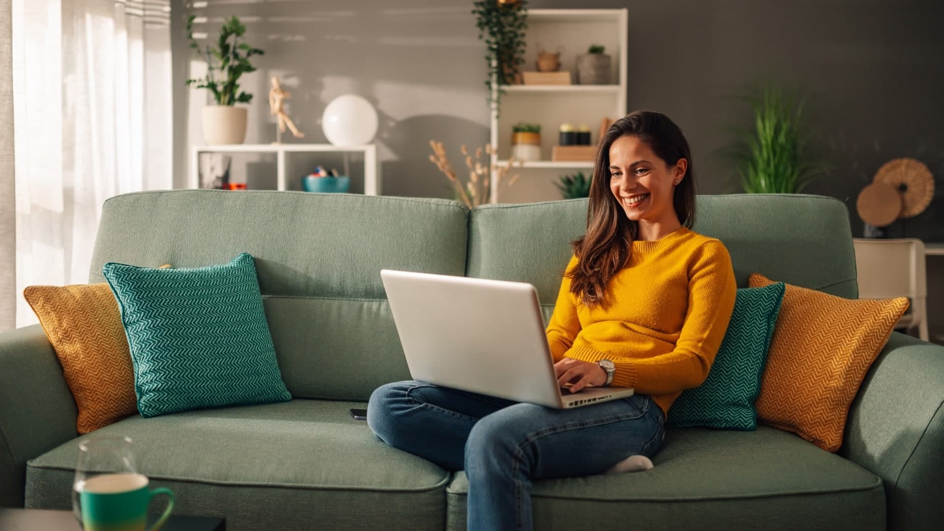 Woman sitting on a sofa browsing on a laptop
